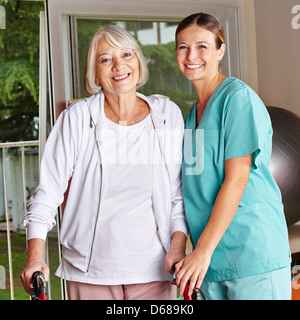 Happy senior Woman Walker und Krankenschwester in einer Physiotherapie Stockfoto