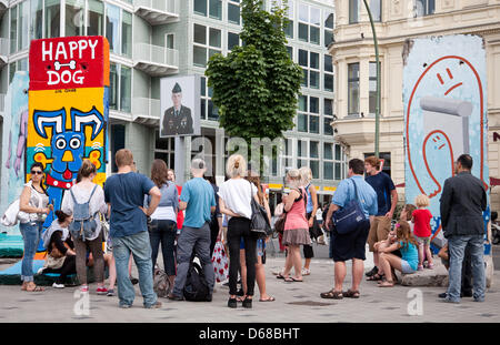 Menschen stehen vor bemalten Stücke der Berliner Mauer am Checkpoint Charlie in Berlin, Deutschland, 2. Juli 2012. Zur Verwendung das Land rund um Berlins berühmtesten ehemaligen Grenzkontrollpunkt seit Jahren gab es ein Streit. Foto: Claudia Levetzow Stockfoto