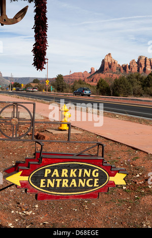 Ein Parkplatz Eingangsschild mit einem Hydranten neben einer Straße und rote Felsen im Hintergrund, Sedona, Arizona, USA Stockfoto