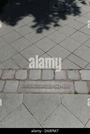 Eine Messingplakette und ein Streifen von Pflastersteinen markiert den ehemaligen Verlauf der innerdeutschen Grenze an der Gedenkstätte Berliner Mauer in der Bernauer Straße in Berlin, Deutschland, 18. Juni 2012. Nach der Wiedervereinigung im Jahr 1990 wurde eine Gedenkstätte für den ehemaligen Bollwerk des Ostens und seiner Opfer am historischen Ort errichtet. Foto: Jens Kalaene Stockfoto