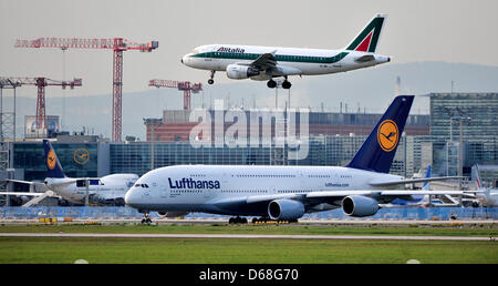 (DATEI) Ein Archivfoto vom 26. September 2011 zeigt ein Alitalia Airbus Landung über ein Lufthansa-Airbus A380 auf dem Flughafen in Frankfurt am Main, Deutschland. Nun, es gibt viele Studien über die Auswirkungen von Ticket Besteuerung auf dem heimischen Markt. Foto: Marc Tirl Stockfoto