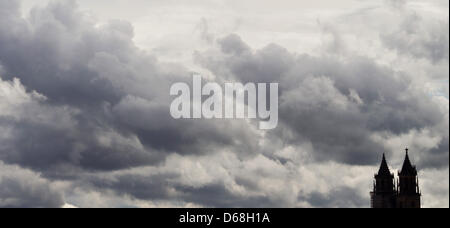 Dunkle Wolken erscheinen über die Türme der Kathedrale "St. Mauritius und St. Katharina" in Magdeburg, Deutschland, 13. Juli 2012. Die Kathedrale ist das Wahrzeichen der Stadt seit mehr als 800 Jahren. Foto: Jens Wolf Stockfoto