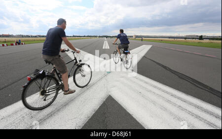 Radfahrer fahren Sie entlang dem ehemaligen Flughafen Tempelhof, Tempelhofer Feld, in Berlin, Deutschland, 15. Juli 2012. Foto: Stephanie Pilick Stockfoto