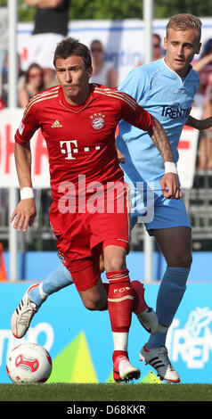 Bayern Mario Mandzukic (L) spielt den Ball bei einem Testspiel zwischen dem FC Bayern München und Trentino in Arco, Italien, 17. Juli 2012. Des Trentino Mattias Tessar ist im Hintergrund zu sehen. Fußball-Bundesligisten FC Bayern München hält einen Vorsaison-Trainingslager für die Saison 2012-2013 Bundesliga in Arco. Foto: Karl-Josef Hildenbrand Stockfoto