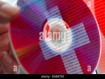 ILLUSTRATION - eine illustrierte Bild zeigt die Schweizer Flagge und Linien von Zahlen in eine CD in Köln, Deutschland, 18. Juli 2012 reflektiert wird. Nordrhein-Westfälischen Finanzbehörden sollen eine weitere CD mit Daten von deutschen Tay Steuerhinterzieher in der Schweiz gekauft haben. Foto: OLIVER BERG Stockfoto