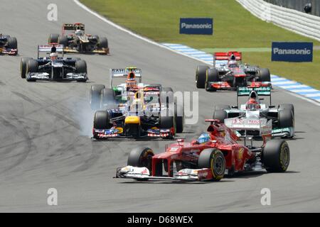 Spanisch-Formel-1-Fahrer Fernando Alonso Ferrari führt vor deutschen Sebastian Vettel (L) von Red Bull, der von seinem Landsmann Michael Schumacher (R) of Mercedes AMG beim Start des Formel 1 Grand Prix von Deutschland auf dem Hockenheimring verfolgen in Hockenheim, Deutschland, 22. Juli 2012 angegriffen wird. Foto: David Ebener Dpa +++(c) Dpa - Bildfunk +++ Stockfoto