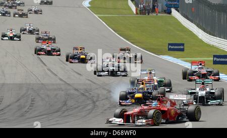 Spanisch-Formel-1-Fahrer Fernando Alonso Ferrari führt vor deutschen Sebastian Vettel (L) von Red Bull, der von seinem Landsmann Michael Schumacher (R) of Mercedes AMG beim Start des Formel 1 Grand Prix von Deutschland auf dem Hockenheimring verfolgen in Hockenheim, Deutschland, 22. Juli 2012 angegriffen wird. Foto: David Ebener dpa Stockfoto