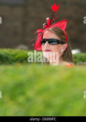 Eine Frau mit einem Hut folgt man der Pferderennen auf der Rennbahn in Berlin Hoppegarten, Deutschland, 22. Juli 2012. Foto: Jörg Carstensen Stockfoto