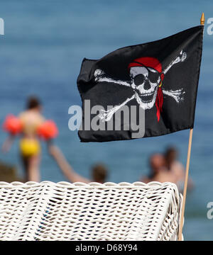 Eine winzige Piratenflagge Wellen in den Wind auf einen Strandkorb an der Ostsee in Ostsee, Deutschland, 24. Juli 2012. Foto: BERND WUESTNECK Stockfoto