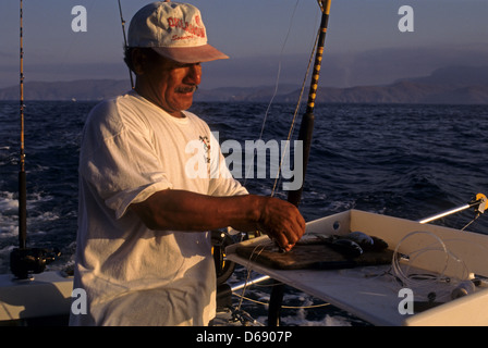 Ein Matrose, rigging, trolling lockt und Köder auf einem Fischerboot Sport in der Nähe von Ixtapa Mexico Stockfoto