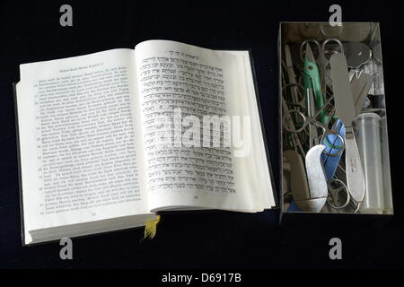 Eine Box mit medizinische Instrumente in die jüdische religiöse Beschneidung Zeremonie Brit Milah liegt neben einem hebräischen Kopie des alten Testaments in den Räumen der israelischen Kultusgemeinde in Hof, Deutschland, 26. Juli 2012. Foto: David Ebener Stockfoto