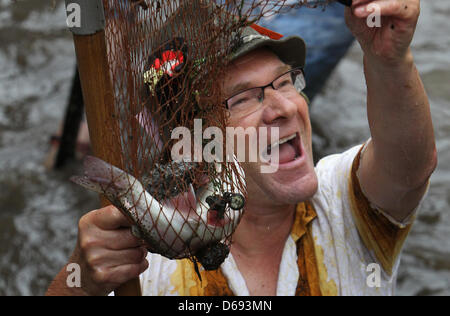 Ein Teilnehmer des traditionellen "Fischertag" Prost auf Fang einer Forelle mit einem Sprung net an einem Stadt-Bach in Memmingen, Deutschland, 28. Juli 2012. 1600 Männer teilgenommen an der Veranstaltung, wo die Person mit der größten Forellen gekrönt "König der Fischer", für ein Jahr. Foto: Karl-Josef Hildenbrand Stockfoto