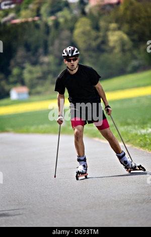 Ein junger Mann-Langlauf mit Roller ski Stockfoto