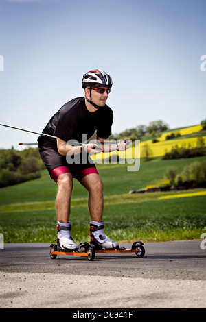 Ein junger Mann-Langlauf mit Roller ski Stockfoto