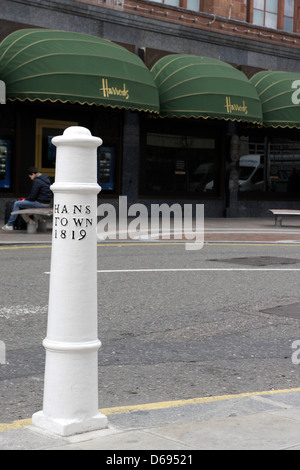 Eine weiße Poller gegenüber Harrods in Hans Crescent, es zeigt an, wo Hans Town war im frühen 19. Jahrhundert. Stockfoto