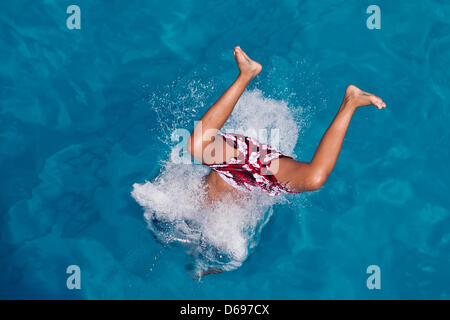 Ein Junge springt in ein Freibad in Nürnberg, 1. August 2012. Sommerliche Temperaturen von bis zu 30 Grad Celsius lockte viele Besucher an den Open-Air-Pool. Foto: DANIEL KARMANN Stockfoto