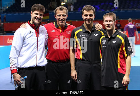 Deutschlands Trainer Joerg Rosskopf, Timo Boll, Dimitrij Ovtcharov (L-R) und Bastian Steger nach dem Sieg gegen das Team von Schweden während der Herren Mannschaft Vorrunde in ExCeL Arena auf die 2012 Olympischen Spiele in London, London, Großbritannien, 3. August 2012 zu feiern. Foto: Friso Gentsch Dpa +++(c) Dpa - Bildfunk +++ Stockfoto