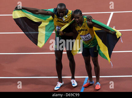 Olympiasieger Usain Bolt (L) und Silbermedaillengewinner Yohan Blake von Jamaika nach 100m Finale der Männer während der London 2012 Olympische Spiele Leichtathletik, Leichtathletik-Veranstaltungen im Olympiastadion, London, Vereinigtes Königreich, 5. August 2012 zu feiern. Foto: Friso Gentsch Dpa +++(c) Dpa - Bildfunk +++ Stockfoto