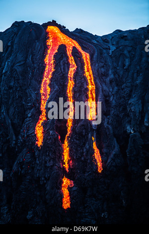 Lava fließt über Felswand Stockfoto