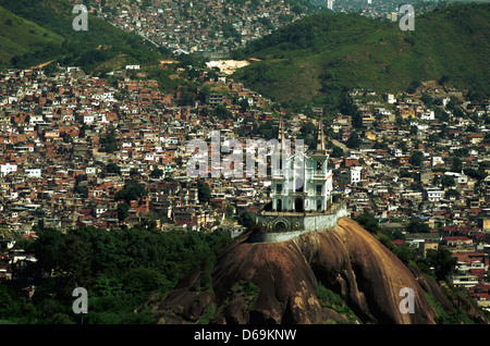 Igrega da Penha (Penha Kirche) umgeben von Favelas von Rio De Janeiro in Brasilien Vila Cruzeiro Slum im Hintergrund. Stockfoto