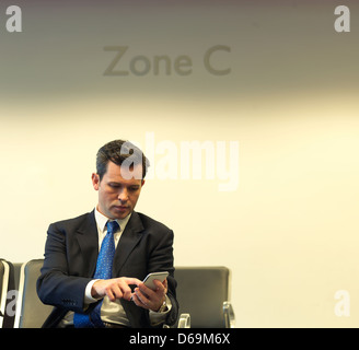 Geschäftsmann mit Handy im Flughafen Stockfoto