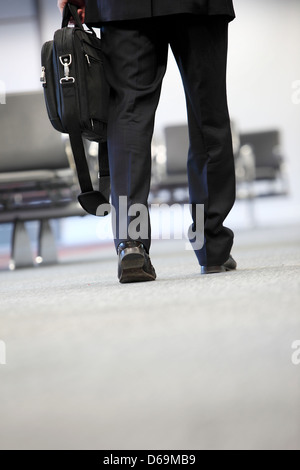 Geschäftsmann zu Fuß in Flughafen Stockfoto