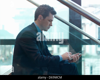 Geschäftsmann mit Handy im Büro Stockfoto