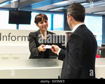 Angestellte an der Rezeption sprechen zum Kaufmann Stockfoto