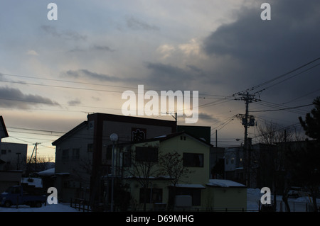 Das Bild zeigt einen Sonnenuntergang über der Küste in Esashi, Hokkaido, Japan, mit einem wunderschönen Regenbogen am Himmel. Die Farben des Himmels vermischen sich am Abend und zeigen leuchtende Lichttöne bei Sonnenuntergang. Stockfoto