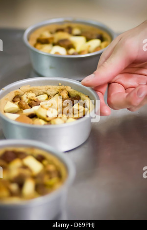 Bäcker mit Dosen von Nusskuchen Stockfoto