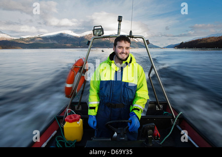 Arbeiter in ländlichen See Boot fahren Stockfoto