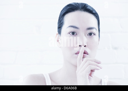 Frau Deckung Lippen mit finger Stockfoto