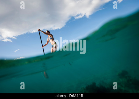 Frau Paddling am Ozean Stockfoto