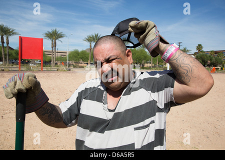 Ein männlicher Insasse fühlt sich die Hitze während Sträflingskolonne Pflicht. Stockfoto