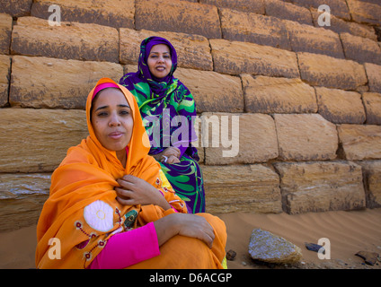 Sudanesischen Frauen vor den Pyramiden und Gräber auf dem Royal Cemetery in Meroe, Sudan Stockfoto