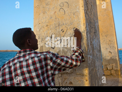 Mann-Writing On The Wall von A ruiniert osmanischen Coral Gebäude, Suakin, Sudan Stockfoto