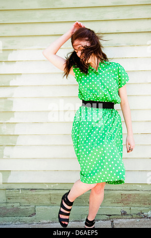 Junge Frau im grünen Kleid mit Polka Dots in Ort springen Stockfoto