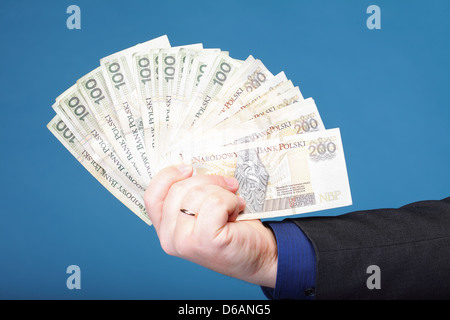 Das Unternehmer Hand mit Polnisch Geld Banknote blau Hintergrund Stockfoto