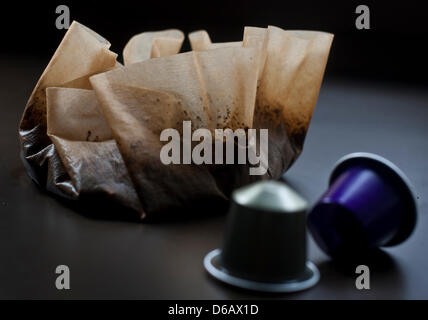 Bunte Kaffeekapseln der Marke Nespresso liegen vor einen gebrauchten Kaffee-Filter auf einem Tisch in München, Deutschland, 9. August 2012. Hersteller von Kaffee-Maschinen und Kapseln Kaffee aufzeichnen Diuble zweistellige Wachstumsraten und investieren Millionen in das Geschäft. Foto: VICTORIA BONN-MEUSER Stockfoto