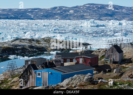 Die kleine Inuit-Jagd-Siedlung Tiniteqilaaq hat etwa 120 Einwohner am Sermilik Fjord, der mit zahllosen Eisberge im Stadtteil Ammassalik Osten Grönlands, Grönland, Dänemark, 17. Juli 2012 fällt. Foto: Patrick Pleul Stockfoto