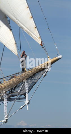 Eine Person hat einen Platz mit einem tollen Blick auf die Vour-Mast-Bark "Star Flyer" genommen, während einer Präsentation der historischen Flotte Segelschiffe auf dem Festival, die, das Hanse Sail an der Ostsee in Warnemünde Pier in Rostock, Deutschland, 11. August 2012 statt. 226 Schiffe sind auf dem maritimen Festival 09 bis 12. August 2012 vorgestellt. Foto: Bernd Wuestneck Stockfoto