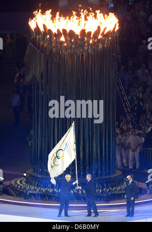 Londoner Bürgermeister Boris Johnson übergibt die Olympische Flagge an Internationale Olympische Komitee (IOC) President Jacques Rogge (C) neben Eduardo Paes (R), Bürgermeister von Rio de Janeiro die Olympische Flamme im Olympiastadion während der Abschlusszeremonie von London 2012 Olympische Spiele, London, Großbritannien, 12. August 2012 vor. Foto: Peter Kneffel Dpa +++(c) Dpa - Bildfunk +++ Stockfoto