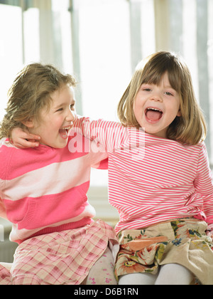 Mädchen lächelnd zusammen drinnen Stockfoto