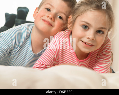 Kinder lachen zusammen auf Bett Stockfoto