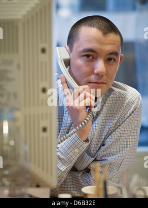 Geschäftsmann am Telefon an der Rezeption sprechen Stockfoto
