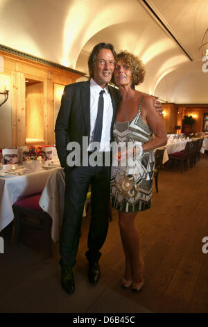 Promi-Arzt stellt Dr. Hans-Wilhelm Müller-Wohlfahrt für Bilder mit seiner Frau Karin während seines 70. Geburtstags-Party am Seehaus in München, Deutschland, 16. August 2012. Dr. Mueller Wohlfahrt ist unter anderem der Club Arzt des Fußball-Bundesligisten FC Bayern München. Foto: Alexander man Stockfoto