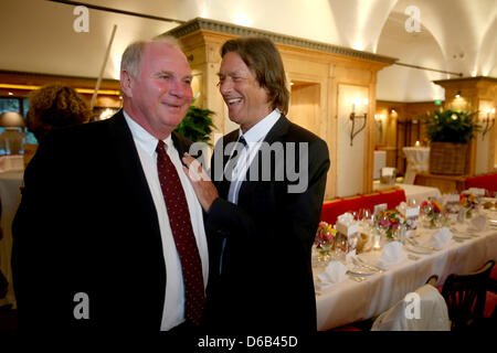 Promi-Arzt Dr. Hans-Wilhelm Mueller Wohlfahrt (R) begrüßt Uli Hoeneß, Präsident des FC Bayern München, während seines 70. Geburtstags-Party am Seehaus in München, Deutschland, 16. August 2012. Dr. Mueller Wohlfahrt ist unter anderem der Club Arzt des Fußball-Bundesligisten FC Bayern München. Foto: Alexander man Stockfoto