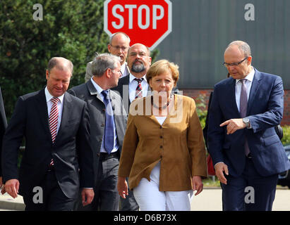 Bundeskanzlerin Angela Merkel, Premier of Mecklenburg-Western Pomerania Erwin Sellering (R) und Manager von P + S-Petkumer in Stralsund und Wolgast Rüdiger Fuchs (L) geben ein Statement am Eingang der Volksweft-Werft in Stralsund, Deutschland, 21. August 2012. Merkel nahm Teil in einer Besprechung über die Zukunft der Schiffbau-Unternehmen, wo waren Vertreter der Medien nicht gestattet. Stockfoto