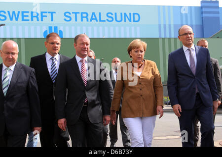 Bundeskanzlerin Angela Merkel, Premier of Mecklenburg-Western Pomerania Erwin Sellering (R) und Manager von P + S-Petkumer in Stralsund und Wolgast Ruediger Fuchs (2 L) geben ein Statement am Eingang der Volksweft-Werft in Stralsund, Deutschland, 21. August 2012. Merkel nahm Teil in einer Besprechung über die Zukunft der Schiffbau-Unternehmen, wo durften Medienvertreter nicht Stockfoto