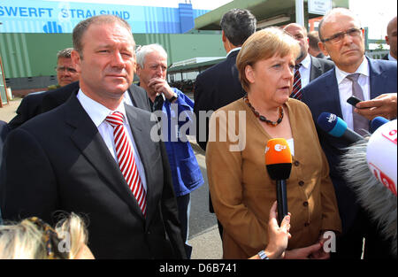 Bundeskanzlerin Angela Merkel, Premier of Mecklenburg-Western Pomerania Erwin Sellering (R) und Manager von P + S-Petkumer in Stralsund und Wolgast Rüdiger Fuchs (L) geben ein Statement am Eingang der Volksweft-Werft in Stralsund, Deutschland, 21. August 2012. Merkel nahm Teil in einer Besprechung über die Zukunft der Schiffbau-Unternehmen, wo waren Vertreter der Medien nicht gestattet. Stockfoto